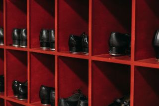 Close up of black tap shoes in red cubbies
